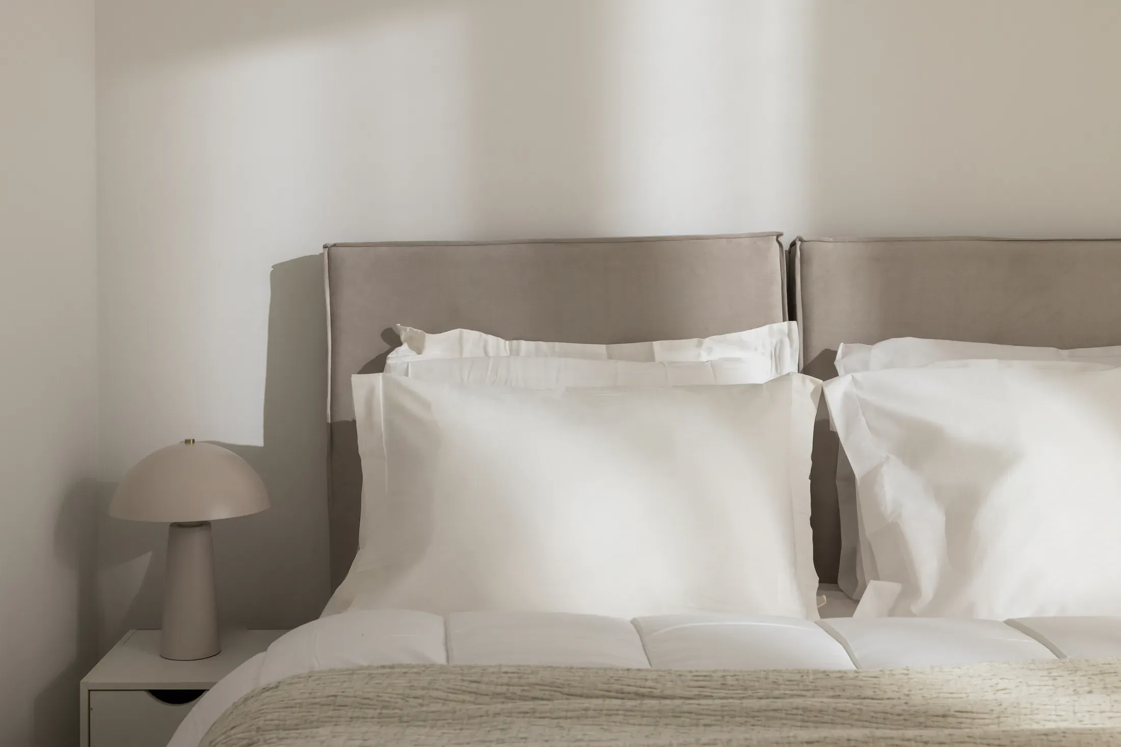 Queen-size bed in a light, neutral bedroom